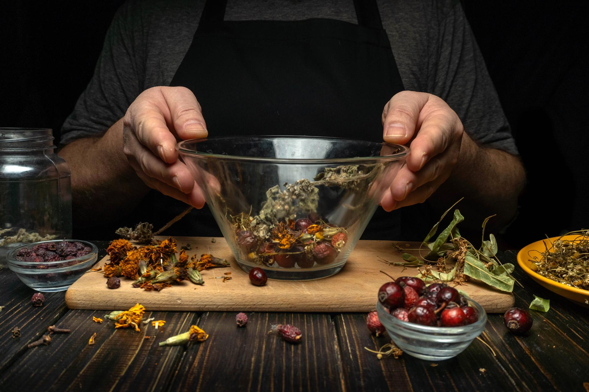 Hands seasoning a pan with herbs